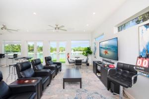 a living room with black leather furniture and a flat screen tv at Summertime Suites #50 in West Bay