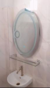 Baño con espejo sobre un lavabo en Salam, en Thiès