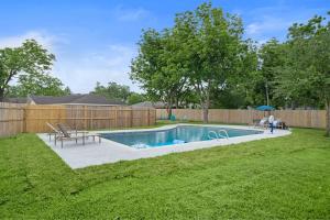 um quintal com uma piscina e uma cerca de madeira em Pool 5 Star Large Deer Park home Super Host em Deer Park