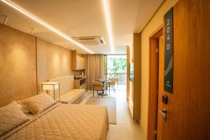 a hotel room with a bed and a living room at Studio Luxo - Melhor trecho da Praia dos Carneiros in Tamandaré +33 photos