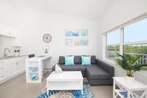 uma sala de estar com um sofá e uma mesa em Summertime Suites #53 em West Bay