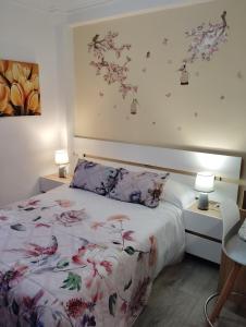 a bedroom with a bed with a floral bedspread at Apartamentos nova de abaixo 3 in Pontevedra