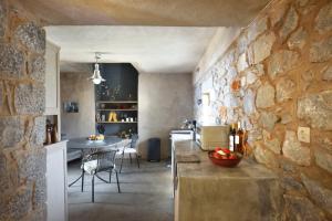 cocina y comedor con pared de piedra en Lagia ZeN Residence, en Láyia