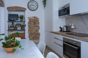 una cucina con tavolo e orologio sul muro di Dimora Pietra Blu a Pisa