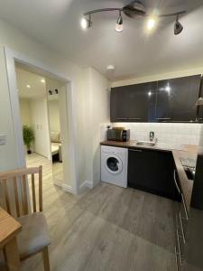 y cocina con lavadora, fregadero y lavadora. en Studio apartment, en Bracknell