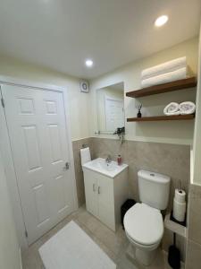 a bathroom with a white toilet and a sink at Studio apartment in Bracknell