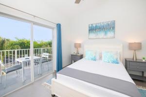 1 dormitorio con 1 cama grande y balcón en Summertime Suites #54 en West Bay