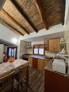 cocina con armarios de madera y encimera en Casa rural abuela Gaspara, en Alcalá del Júcar