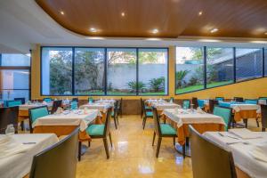 a restaurant with tables and chairs and large windows at Hotel Blaucel in Blanes