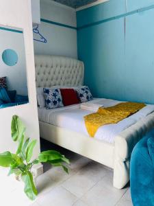 a bedroom with a white bed with blue walls at Budget Studio. Nakuru CBD. Wifi. Spacious. Ample Parking in Nakuru