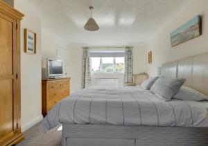 a bedroom with a large bed and a television at Avocet House in Langham