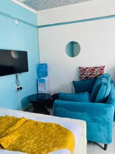 a living room with blue furniture and a couch at Budget Studio. Nakuru CBD. Wifi. Spacious. Ample Parking in Nakuru