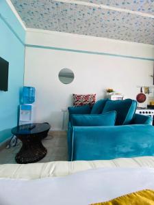 a living room with a blue couch and a table at Budget Studio. Nakuru CBD. Wifi. Spacious. Ample Parking in Nakuru