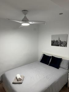a bedroom with a white bed with a hat on it at Manrique Rooms in Málaga