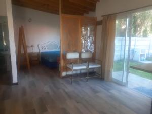 a bedroom with a bed and two chairs in it at Brisas de Atlantida in Santa Clara del Mar