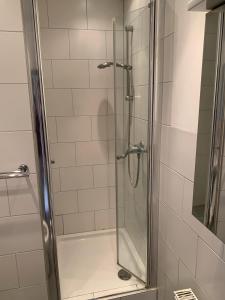 a shower with a glass door in a bathroom at Haus Check-In in Gütersloh