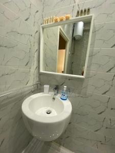 a white bathroom with a sink and a mirror at Joli Studio au Centre Ville avec WIFI - Netflix in Casablanca