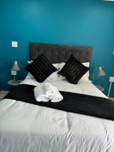 ein Bett mit schwarzen Kissen und zwei Handtüchern darauf in der Unterkunft Entindini guest house in Empangeni