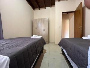 1 dormitorio con 2 camas y puerta a una habitación en Casa tranquila y cómoda, muy cerca del centro en Tunuyán