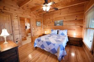 1 dormitorio con 1 cama en una cabaña de madera en Brew with a View Lodge, en Ducktown