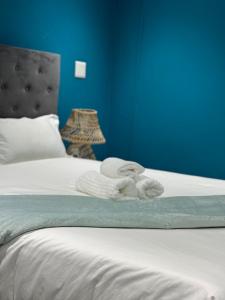 a blue bedroom with a bed with towels on it at Entindini guest house in Empangeni