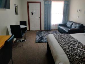 a hotel room with a bed and a couch and a table at Sandstock Motor Inn Armidale in Armidale
