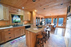 cocina con armarios de madera y barra con taburetes en Golden Mountain Tops- Suches, en Suches
