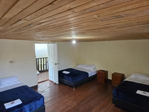 Habitación con 2 camas y techo de madera. en Casa Guicán, en Güicán