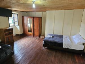 1 dormitorio con 1 cama y suelo de madera en Casa Guicán, en Güicán