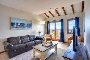 a living room with a couch and a tv at Bright Catalina Island Condo with Ocean Views! in Avalon