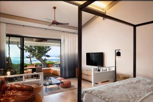 Schlafzimmer mit Deckenventilator und Wohnzimmer in der Unterkunft Ocean Bungalows at Turtle Bay Resort in Kahuku