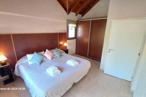 a bedroom with a large bed with two pillows on it at Huapi II in Dina Huapi