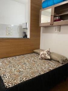 a room with a bed with a leopard pattern on it at Conjugado Próximo aos Arcos da Lapa e Praia do aterro do Flamengo in Rio de Janeiro