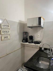 a small kitchen with a sink and a microwave at Conjugado Próximo aos Arcos da Lapa e Praia do aterro do Flamengo in Rio de Janeiro
