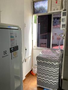 a kitchen with a refrigerator and a window at Conjugado Próximo aos Arcos da Lapa e Praia do aterro do Flamengo in Rio de Janeiro