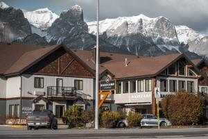 a hotel with snow covered mountains in the background at Basecamp Lodge Canmore in Canmore