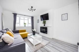 ein Wohnzimmer mit einem Sofa und einem TV in der Unterkunft Modern 2 Bedroom Apartment Brixton Station in London