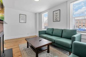 ein Wohnzimmer mit einem grünen Sofa und einem Couchtisch in der Unterkunft Housepitality - The Marienplatz - Free Parking in Columbus