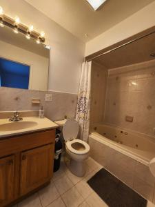 a bathroom with a toilet and a sink and a tub at Bright & Spacious 3-Bed Close to NYC in Jersey City
