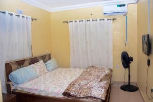 um quarto com uma cama com uma cortina branca em Rehoboth hotel, Apartment and Event services em Suberu Oje