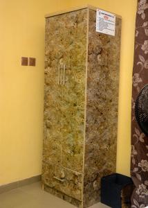 Cette chambre dispose d'une douche et d'un mur en pierre. dans l'établissement Rehoboth hotel, Apartment and Event services, à Suberu Oje
