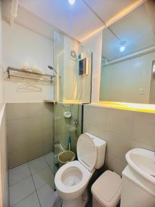 y baño con aseo y ducha acristalada. en CasadeIsabel: Elegant 2BR n Cebu/Washing/Netflix en Cebú