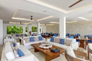 sala de estar con muebles blancos y detalles en azul en The House by Elegant Hotels - All-Inclusive, Adults Only en Saint James