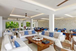 a living room with white furniture and blue accents at The House by Elegant Hotels - All-Inclusive, Adults Only in Saint James