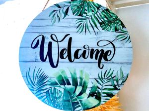 a welcome sign with leaves on a wooden wall at Emerald inn at runaway bay in Runaway Bay