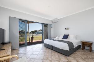a bedroom with a bed and a sliding glass door at Windsurfer Beach Studio in Lancelin