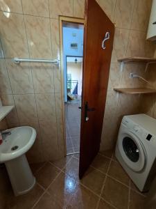 een badkamer met een wastafel en een wasmachine bij Apartments Kalamperovic in Bar