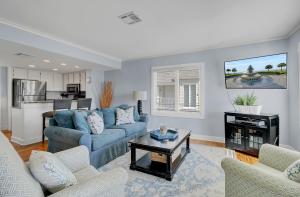 a living room with a blue couch and a table at 304 E Port by AvantStay Rooftop Deck Close to Beach in Isle of Palms