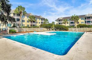 a swimming pool in front of some apartment buildings at 304 E Port by AvantStay Rooftop Deck Close to Beach in Isle of Palms