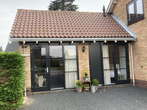 a conservatory with black doors on a brick house at 't Huske in Werkendam